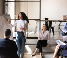 Women presenting to a group of professionals covering diversity, inclusion, culture and ethics